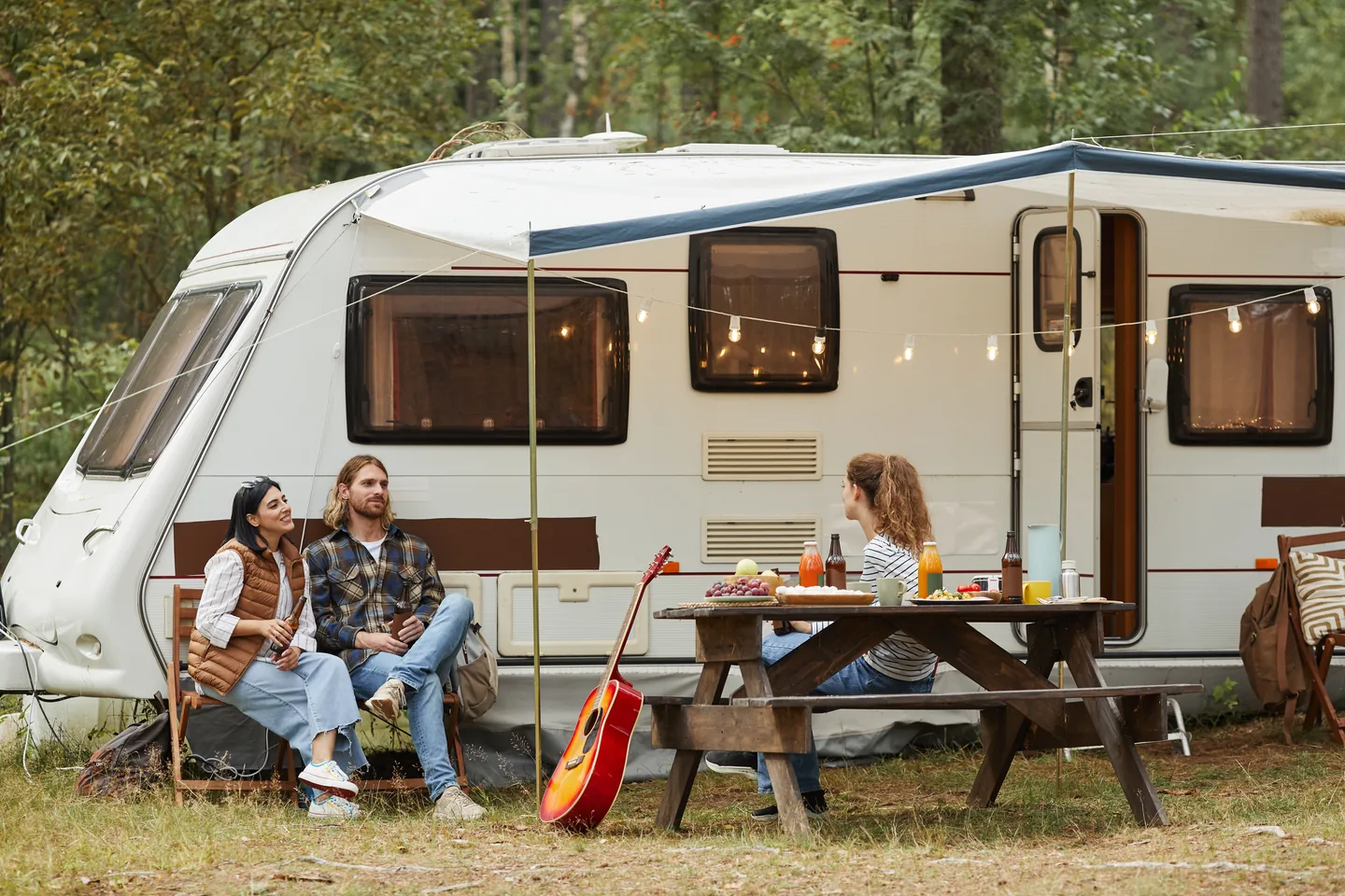 Friends enjoying time together beside a caravan